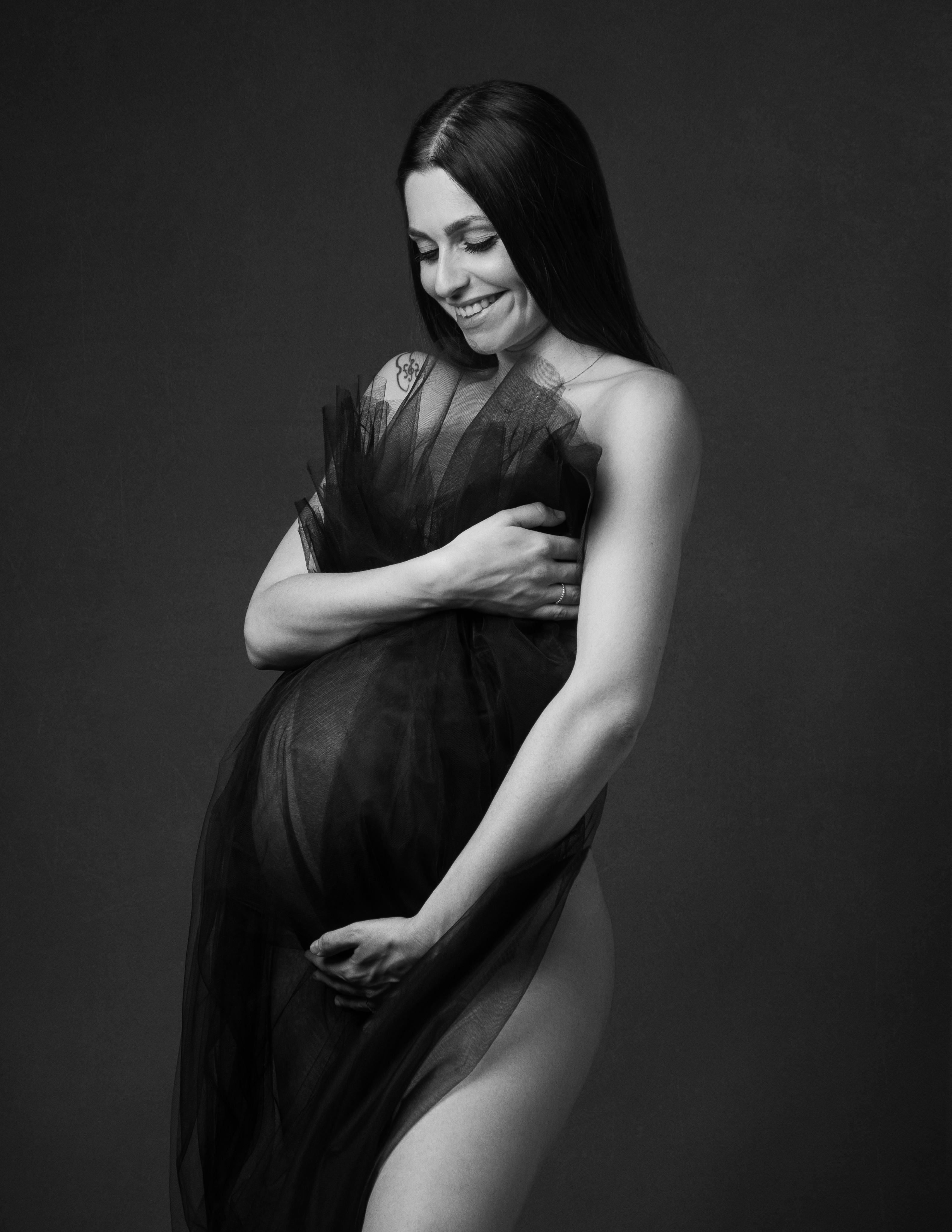 Set fotografico maternity in studio, luce naturale e tessuti fluidi